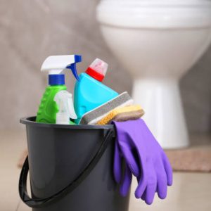 Bucket with cleaning supplies on floor in bathroom